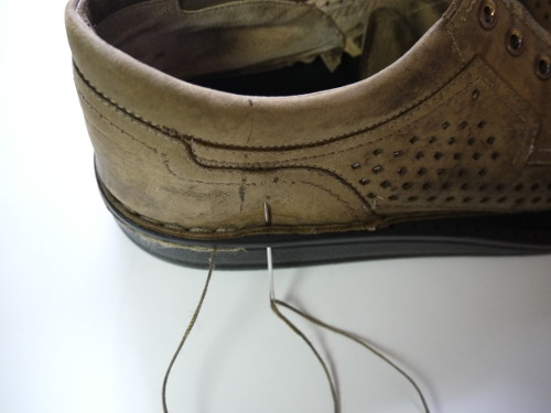 sewing new soles onto old leather shoes